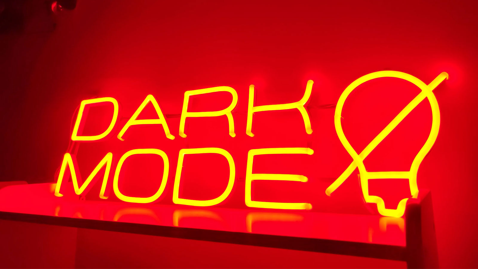 A neon sign in orange color with the text “DARK MODE”