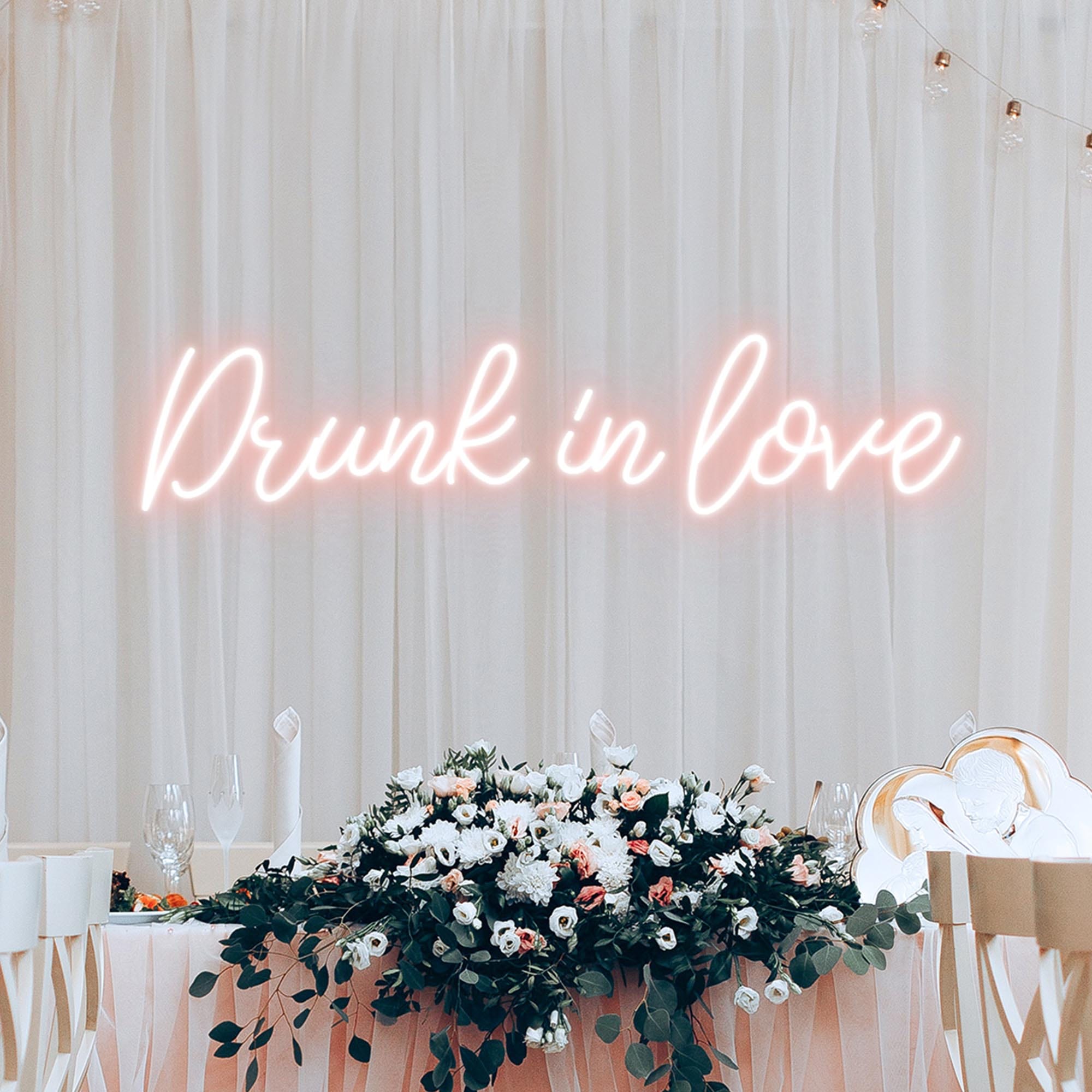 A pink neon sign with the letters "Drunk in Love" was hung in a wedding ceremony